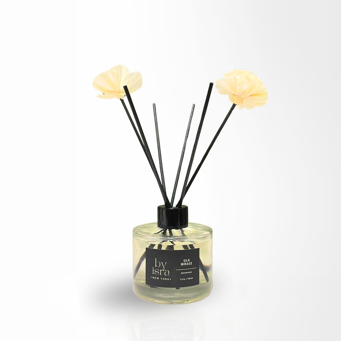 Diffuser with floral reeds and a clear bottle on a white background