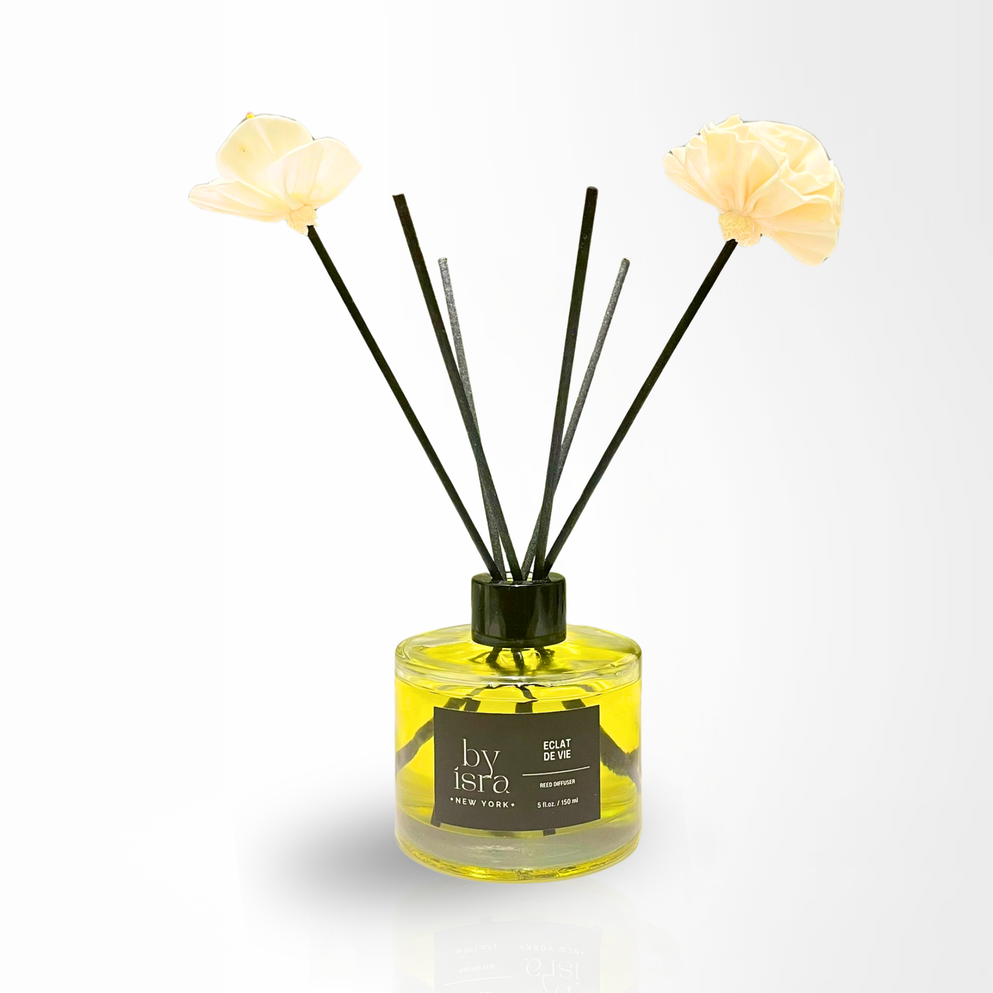 Reed diffuser with decorative flowers on a white background