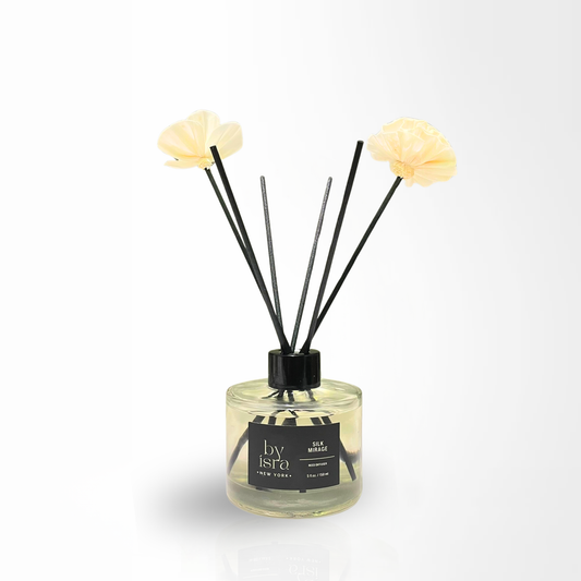 Diffuser with floral reeds and a clear bottle on a white background