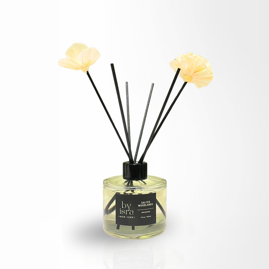 Diffuser with floral elements and 'by Isra' branding on a white background