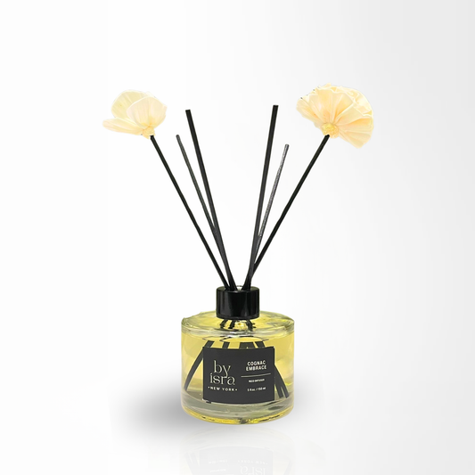 Diffuser with floral ends and black sticks on a white background