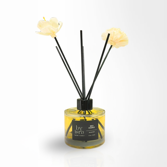 Reed diffuser with floral elements on a white background