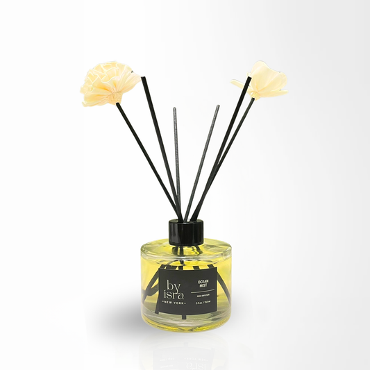 Reed diffuser with floral elements on a white background